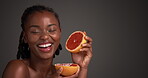 Grapefruit, laugh or woman in studio with skincare, antioxidant or benefit in facial glow. Nutrition, vitamin C or dermatology on gray backdrop with fruit, collagen boost or UV protection from citrus