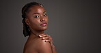 Shoulder, beauty and face of black woman in studio for skincare, body care and clear skin glow. Dermatology, shine and hydration with female person on dark background for mockup space and aesthetic