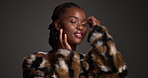Skincare, face and black woman in studio with beauty makeup for style, glamour or elegance. Fur coat, trendy and happy model with lipstick cosmetics, luxury aesthetic or touch skin on dark background