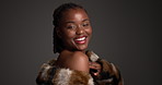 Face, black woman and smile with luxury skincare in studio for cosmetics, dermatology and glamour. Female person, beauty and fur coat for aesthetic, healthy skin and natural shine on dark background