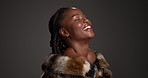 Happy, black woman and laugh with luxury skincare in studio for cosmetics, dermatology or facial glow. Female person, beauty and fur coat of aesthetic, funny joke and natural shine on dark background