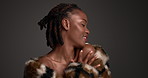 Skincare, body care and black woman in studio with beauty makeup, style and luxury aesthetic. Fur coat, face and happy model with lipstick cosmetics, glamour and touch skin on dark background
