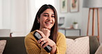 Funny, remote and watching tv with woman on sofa in living room of home for streaming. Comedy, entertainment and laughing with happy Indian person in apartment for video subscription service