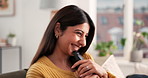 Laughing, remote and television with woman on sofa in living room of home for streaming. Comedy, entertainment and funny with happy Indian person watching tv in apartment for video subscription