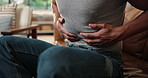 Hands, man and stomach ache in home, pain and gas with IBS on sofa. Sick, diarrhea and person with abdomen cramps, food poisoning emergency and health problem with constipation in living room