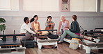 Break, laughing and reformer with women in gym together for bonding, health or wellness. Diversity, fitness and training with group of funny friends talking in pilates class for exercise or workout