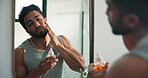 Man, mirror and serum for skincare in bathroom for hydration, collagen benefits and natural beauty. Male person, reflection and cosmetics for dermatology, hyaluronic acid and treatment shine at house