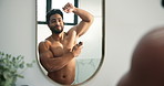 Man, mirror and spray armpit in bathroom for hygiene, smell fresh and grooming for odor control. Male person, reflection and deodorant for clean fragrance, body cosmetic and sweat prevention at house