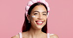 Happy woman, face and studio with cream for facial treatment or glow on a pink background. Portrait, female person or model with smile, cosmetics or lotion for skin moisturizer or shine on space