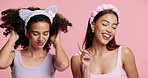 Dance, friends and women in studio for skincare, beauty and facial treatment with headband for self care. Happy, movement and people with cosmetics, pamper and glow for wellness on pink background