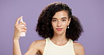 Face mist, skincare and woman in studio with cosmetic, beauty and facial treatment for health. Happy, hydration and portrait of person with setting spray for dermatology routine on purple background