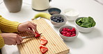 Person, hands and cutting with strawberries for diet, smoothie or healthy meal prep in kitchen. Nutritionist, ingredients and chopping board with natural organic fruit or blender for vitamins in home