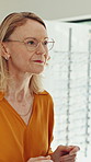 Glasses, optometry and old woman in store, choice and spectacles with positive attitude. Pensioner, client and mature person with eyewear, clear vision and consumer with decision, frame and shopping