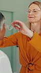 Optometrist, mature woman and choice for glasses for eye test, talk and assessment for vision at clinic. People, ophthalmology and patient with spectacles, discussion and check eyesight at hospital