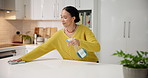 Woman, spray and cloth on kitchen counter in home, smile or routine for hygiene, dust or germs. Person, bottle and liquid for bacteria, spring cleaning or happy with product for dirt removal at house