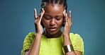 Pain, headache and black woman in studio with stress, mental health challenge or vertigo. Sick, migraine and African person with tension, breathing or massage temples for fatigue on blue background