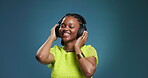 Headphones, dancing and black woman by studio background with listening to music or playlist. Happy, audio tech and African female person moving to album, radio or song for fun, rhythm and groove.