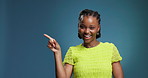 Black woman, face and point in studio with mockup space, smile and choice on blue background. African girl, gesture and happy in portrait with decision, review and excited with feedback in Nigeria
