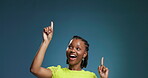 Happy, black woman and pointing gesture in studio for advertising, presentation and information. Female person, direction and mockup space for results, coming soon and announcement on blue background