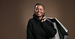 Black woman, face and shopping bag in studio with smile, retail therapy or excited with sale on background. African girl, happy and portrait with customer experience, discount deal and pride in Kenya