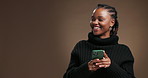 Black woman, phone and happy in studio, texting and thinking with chat for online dating on background. African girl, smartphone and fashion with mockup space, mobile app and smile with social media
