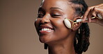 Smile, black woman and roller for skincare in studio with beauty, facial massage and detox. Happy, person and cosmetic tools for lymphatic drainage, dermatology and natural shine on brown background