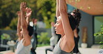 Woman, stretching and group for yoga class at resort, fitness and breathing with warrior lunge on patio. Girl,   people and balance outdoor with exercise and self care at wellness retreat for healing