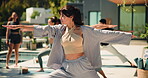 Woman, stretching and group for yoga at resort, fitness and instructor with warrior lunge on patio. Female person, class and balance outdoor with exercise, trainer and self care at wellness retreat