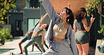 Woman, stretching and class for yoga at resort, fitness and instructor with warrior pose on patio. Female person, group and balance outdoor with exercise, trainer and self care at wellness retreat
