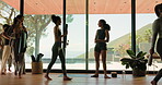 Fitness instructor, people or walking in yoga class with welcome for workout, healthy body or wellness. Coach, clients or enter in studio with greeting for mat pilates, mobility or physical wellbeing