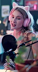 Conversation, microphone and podcast with woman in bunny ears for content creation or broadcast. Headphones, live streaming and recording with happy influencer in studio for advertising or marketing
