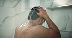 Man, shower and grooming in bathroom for cleaning, wellness and washing hair in home. Male person, house and running water in morning for skincare, splash and fresh body with cosmetics and shampoo