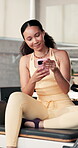 Smile, phone and thinking with woman in pilates studio for social media, workout post and online. Communication, fitness update and reflection with person in club for wellness, vision and connection
