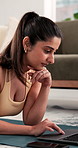 Education, laptop and typing with woman on floor in living room of home for learning or study. Computer, homework an reading with happy Indian student in apartment for college or university research