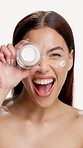 Face, cream and woman with smile, cosmetics and dermatology with glow, funny and container. Aesthetic, creme and person with lotion, skincare and shine with treatment on white studio background