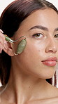 Face, woman or beauty in studio with jade roller for lymphatic drainage, skincare or dermatology. Confident, person or facial tool for blood circulation, healthy skin or wellness on white background.