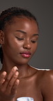 Cream, skincare and black woman with beauty, container and dermatology on grey studio background. African person, glow or lotion with healthy skin, cosmetics or aesthetic with luxury product or creme
