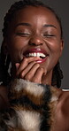 Face, black woman and laugh for skincare in studio with cosmetics, dermatology and facial shine. Female person, beauty and fur coat for aesthetic, funny joke and natural treatment on gray background
