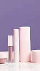 Empty, bottle and cosmetics in studio for beauty, skincare and product review on purple background. Space, salon and selection of container for shine, hydration or aesthetic for dermatology campaign