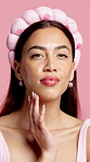 Beauty, hand and face of woman in studio for skincare, facial grooming and aesthetic glow. Dermatology, hydration and collagen benefits with portrait of person on pink background for cosmetology