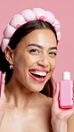Bottle, face and skincare with woman in studio for advertising or marketing of cosmetic product. Beauty, container and recommendation with happy person on pink background for dermatology advice