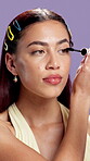 Beauty, face and woman in studio with mascara, define and enhance eyelash with cosmetic tool. Portrait, gen z and girl on purple background with brush, volume and product lift in makeup application.