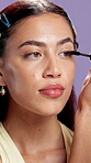 Beauty, makeup and mascara with face of woman in studio for shine, growth and self care. Eyelash extension, aesthetic and volume tool with portrait of person on purple background for cosmetics