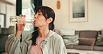 Fitness, drink water and woman in living room, indoor activity and difficult exercise for thirst. Hydration, workout routine or person relax with liquid in home, break or rest for practice completion
