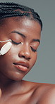 Skincare, woman or relax in studio with jade roller for lymphatic drainage, beauty or dermatology. Calm, black person or facial tool for blood circulation, healthy skin or wellness on gray background