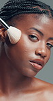 Face, black woman and makeup brush for beauty in studio for glow, foundation and aesthetic. Portrait, female person and cosmetic tools for makeover, facial powder and natural shine on gray background