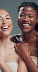 Beauty, face and hug with women laughing in studio for cosmetics or dermatology satisfaction. Aesthetic, funny and skincare with model friends embracing on gray background for benefits or results