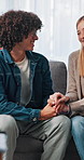 Happy, couple or holding hands in therapy on sofa for relationship healing, reconciliation or advice. Consultation, people and speaking to therapist for pre marital counseling or communication skills