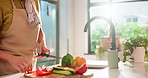 Hands, knife and cooking with vegetables in kitchen with cloth, meal prep and organic ingredients in home. Person, pepper and chef with food, apron or diet with nutrition for wellness at apartment