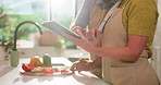 Hands, tablet and couple in kitchen with vegetables, home and scroll online for recipe. People, chef and partner for food with reading notes, ingredients or typing for meal prep on app at apartment